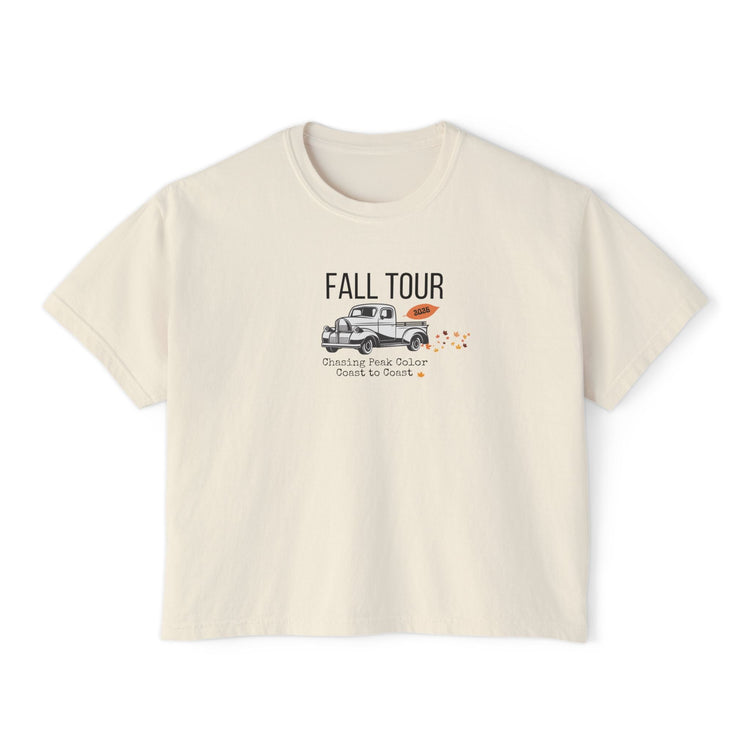 A cream-colored short-sleeve t-shirt with a graphic on the front that reads 'FALL TOUR' above an illustration of a pickup truck and small orange leaves.