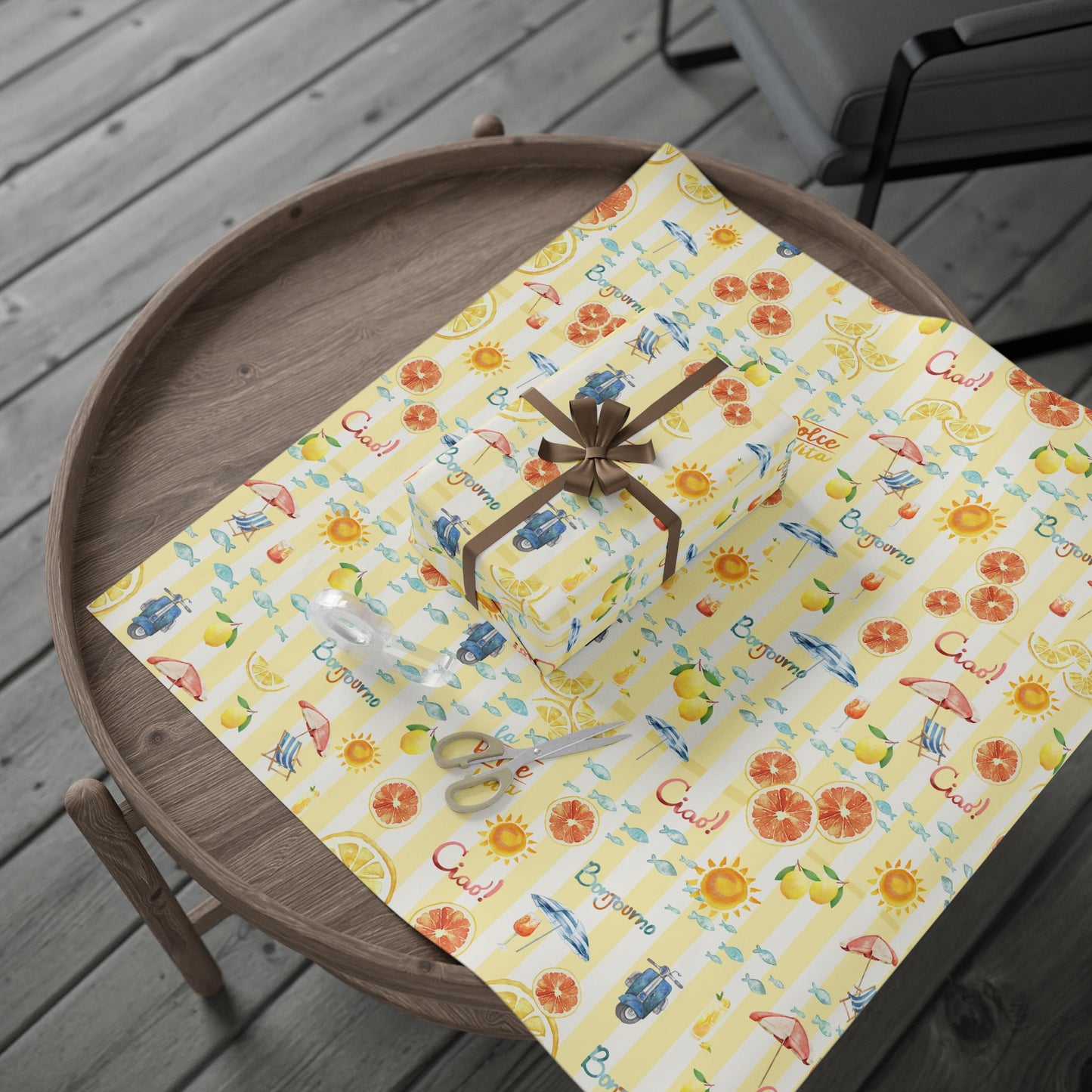 Gift box on a decorative yellow paper with patterns on a wooden tray.