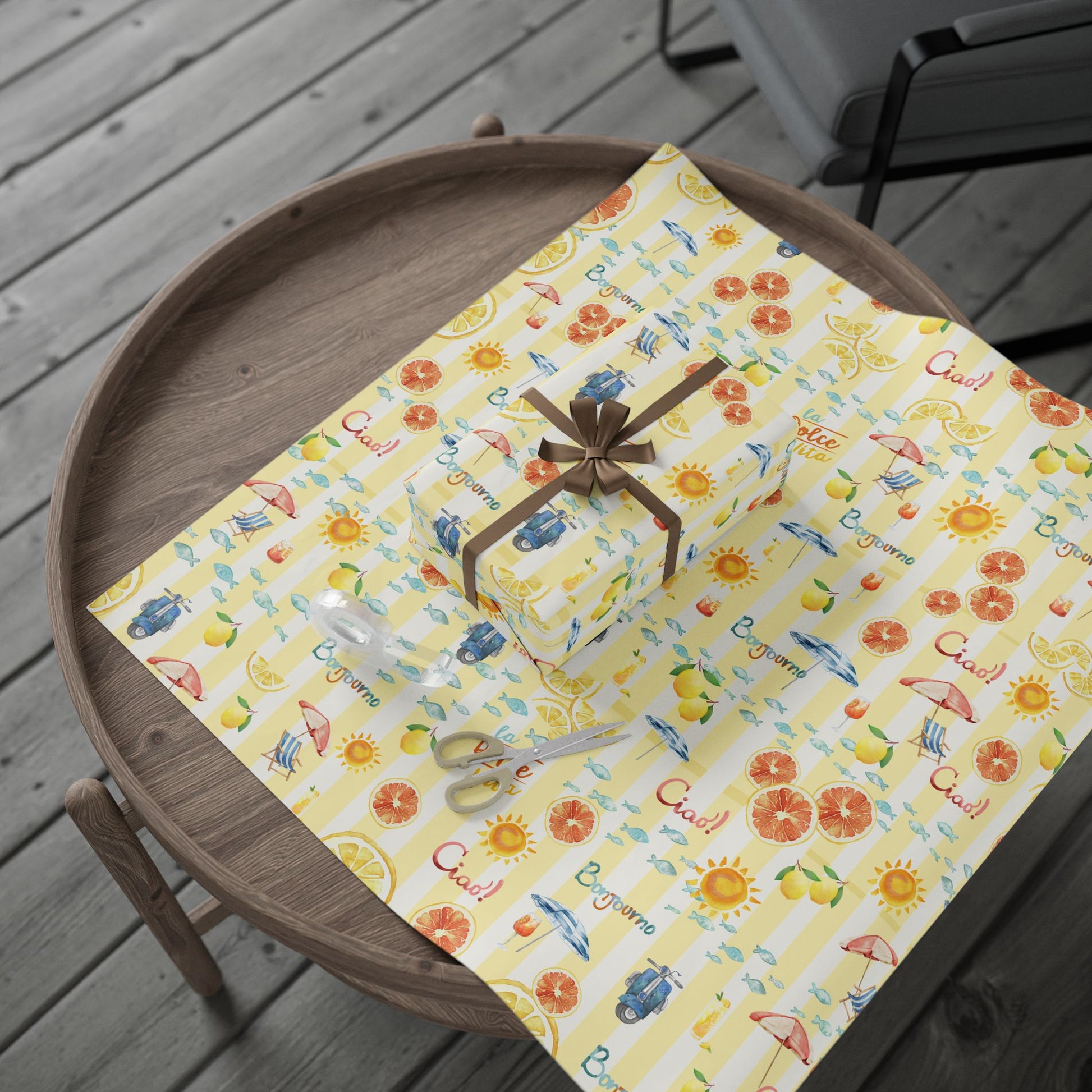 Gift box on a decorative yellow paper with patterns on a wooden tray.