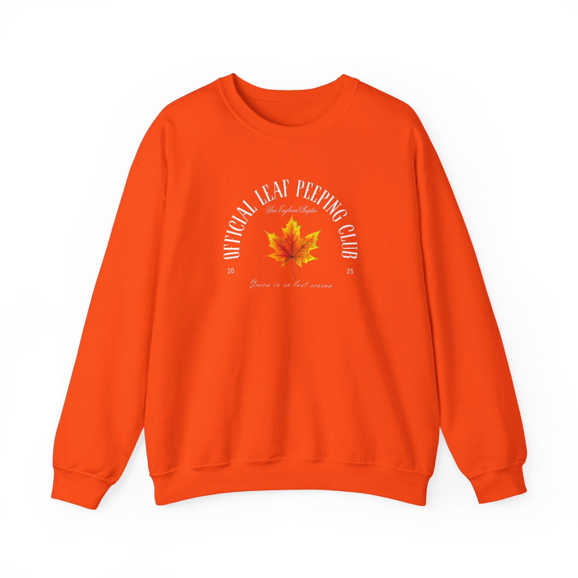 A bright orange crewneck sweatshirt featuring a small cartoon illustration of a maple leaf and fall text the center chest, displayed against a clean white background.