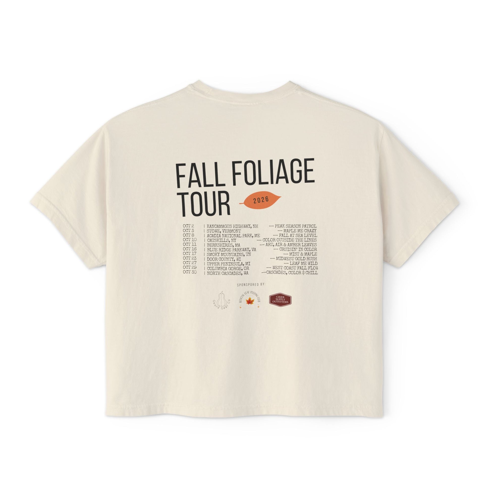 An off-white short-sleeve t-shirt showing the back side with a graphic print that reads 'FALL FOLIAGE TOUR 2026' above a tracklist and small illustrations, photographed on a solid white background.