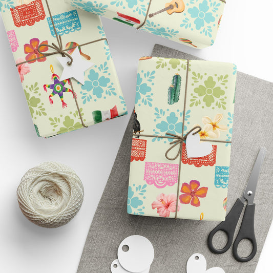 Gift boxes wrapped in colorful Mexico paper with scissors and yarn on a white surface