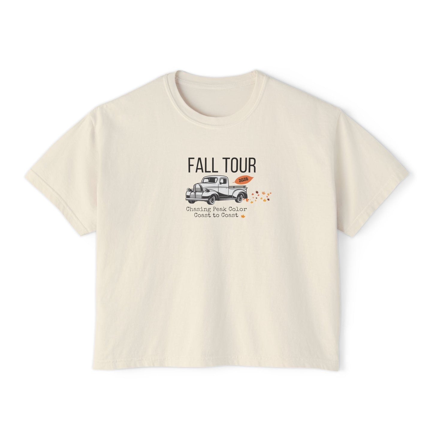 A cream-colored short-sleeve t-shirt with a graphic on the front that reads 'FALL TOUR' above an illustration of a pickup truck and small orange leaves.