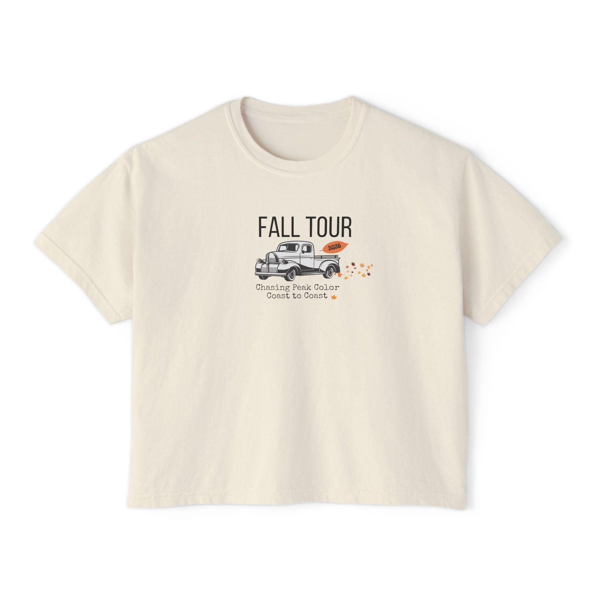A cream-colored short-sleeve t-shirt with a graphic on the front that reads 'FALL TOUR' above an illustration of a pickup truck and small orange leaves.